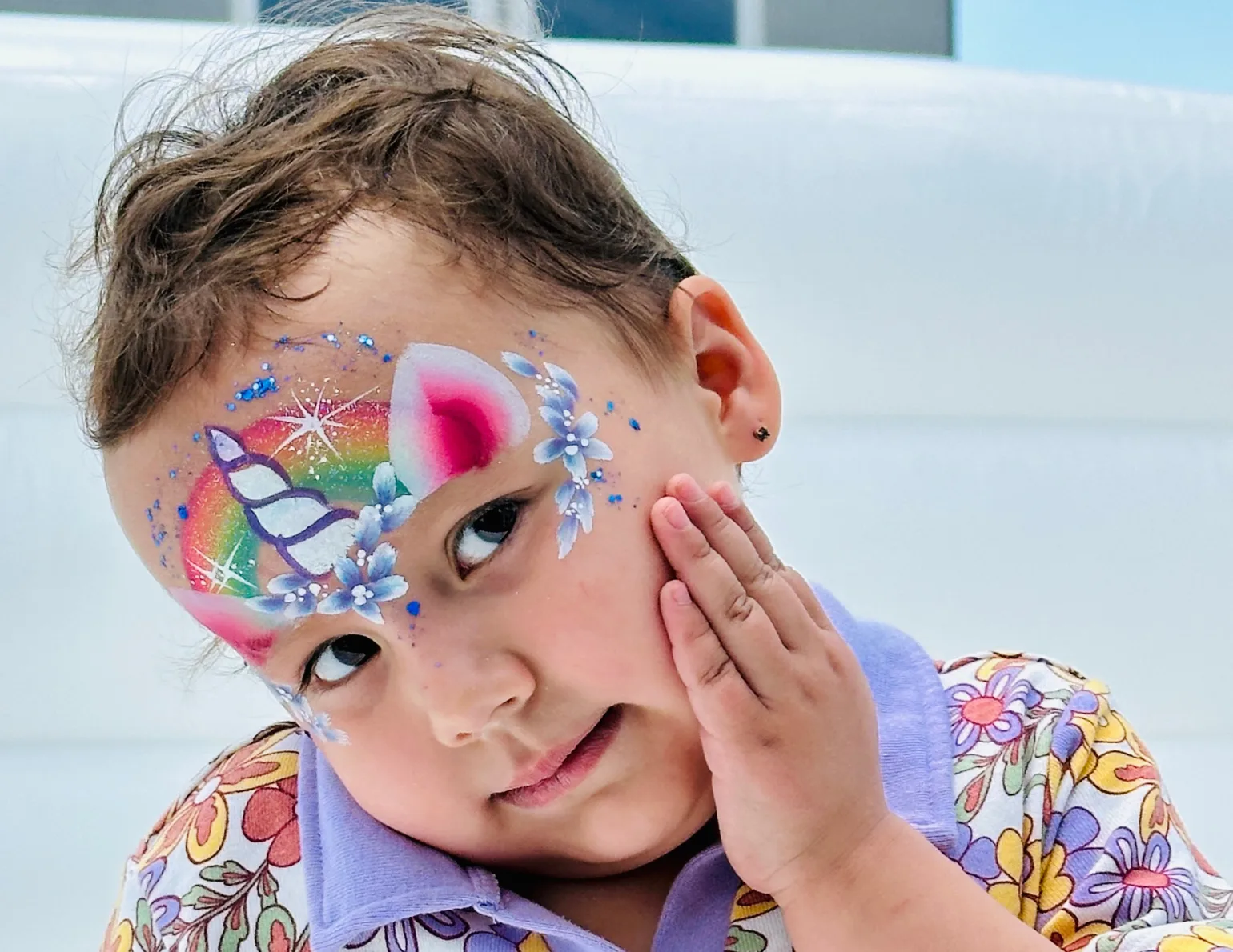 Child with pastel butterfly face painting.