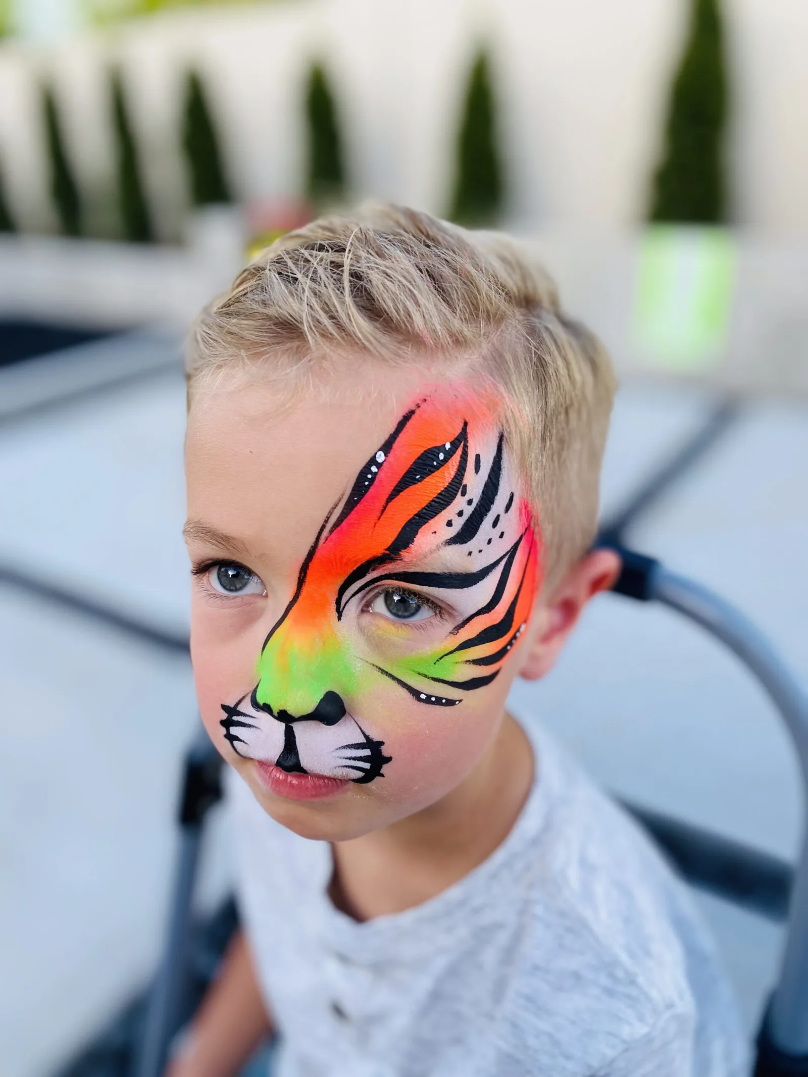 Child with rainbow tiger face painting portrait.