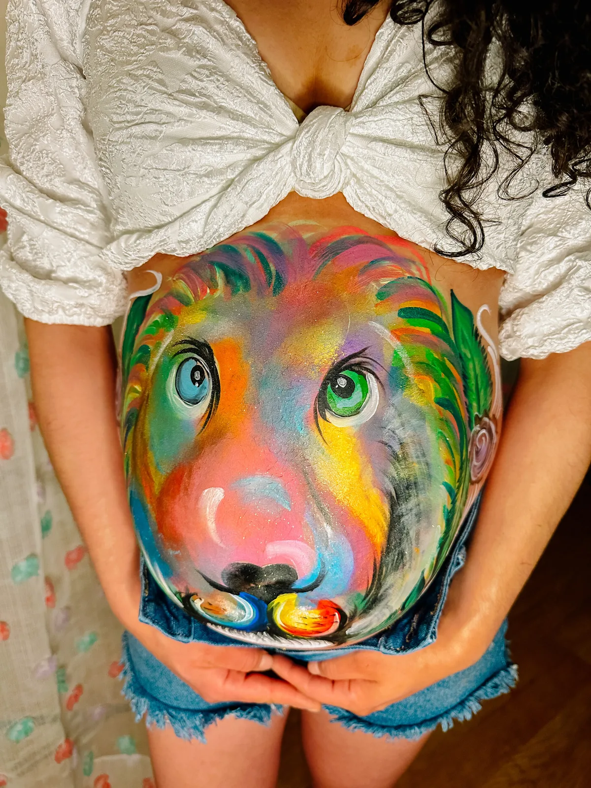 Close-up of colorful lion pregnancy belly painting.