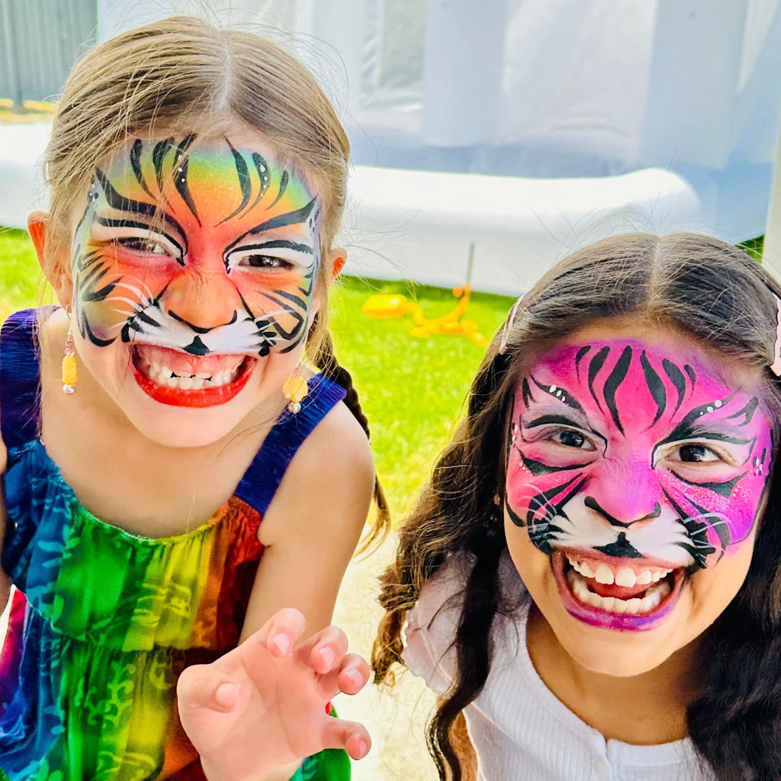 Two smiling children with tiger face painting.