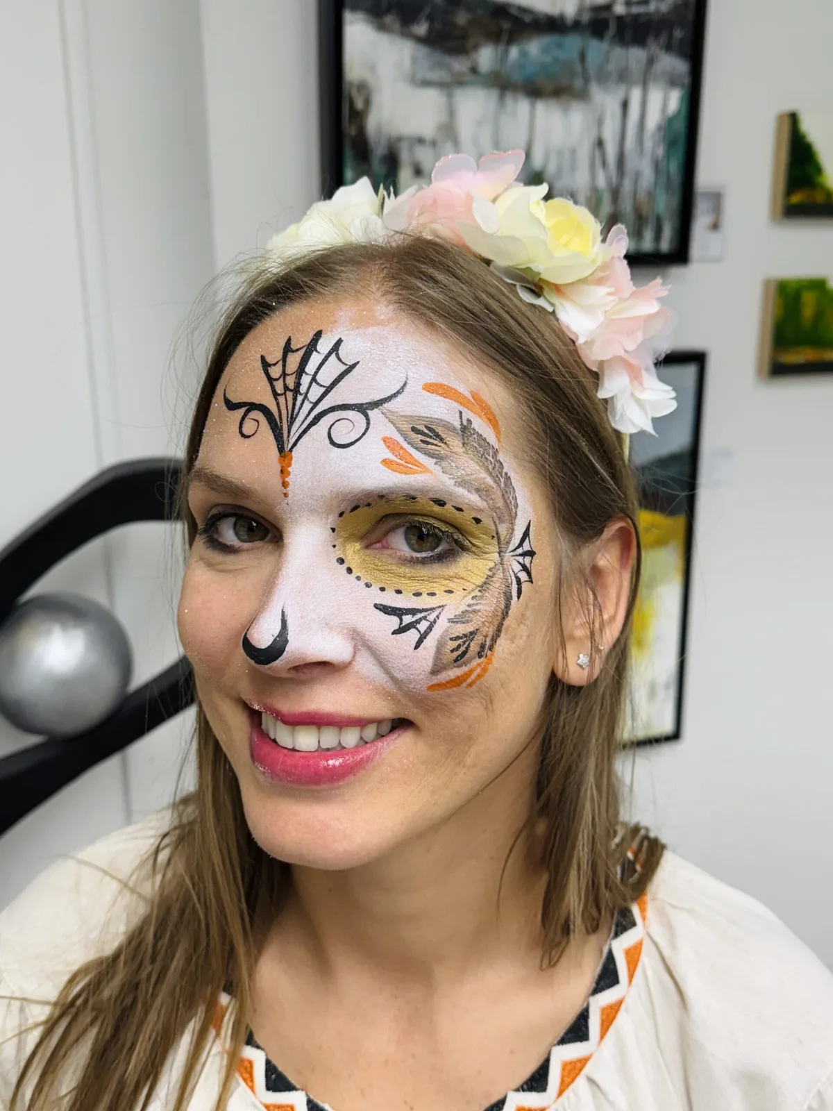 Woman with gold sugar skull face painting close-up.